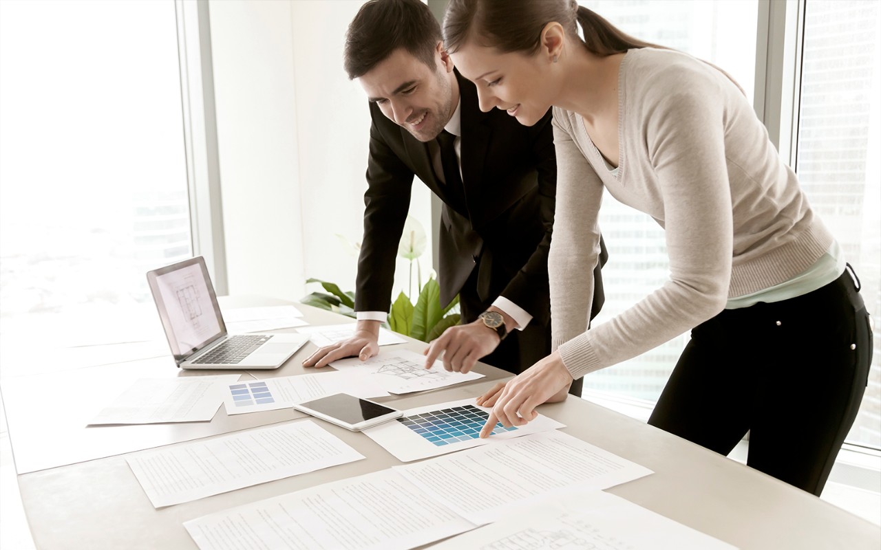 Ein Mann und eine Frau bei der Arbeit, sie analysieren Dokunente.