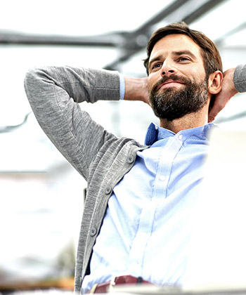 Man with hands behid his had