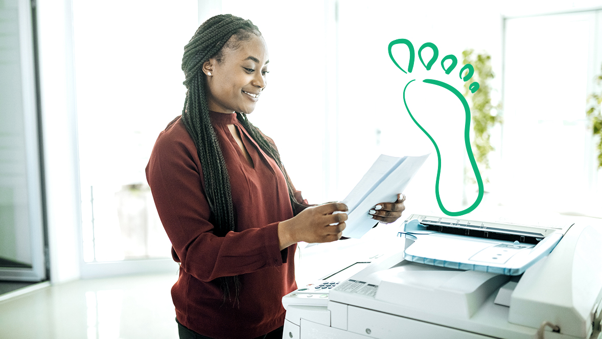 Eine Frau die an einem Kopierer Dokumente ausdruckt.