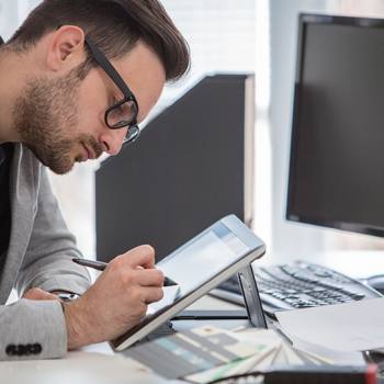 99% unserer Produkte sind "grün" man working on a tablet with a stylus