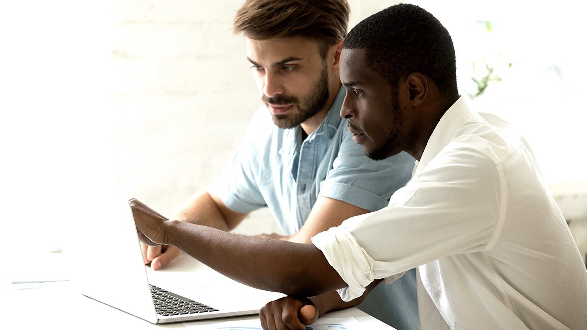 two colleagues working at a laptop two colleagues working at a laptop